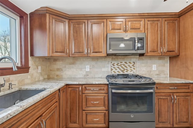 kitchen with stainless steel appliances, sink, backsplash, and light stone counters