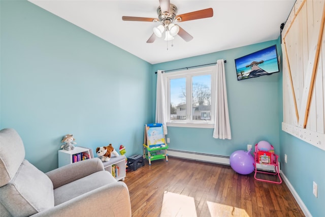 game room featuring a baseboard radiator, wood-type flooring, and ceiling fan