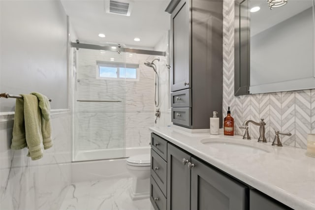 full bathroom with tasteful backsplash, enclosed tub / shower combo, vanity, and toilet