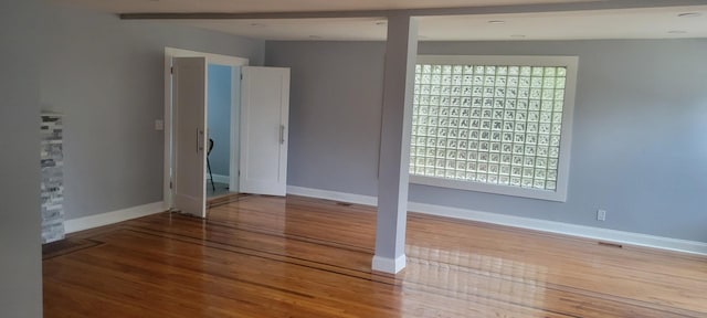 empty room with wood-type flooring and a wealth of natural light