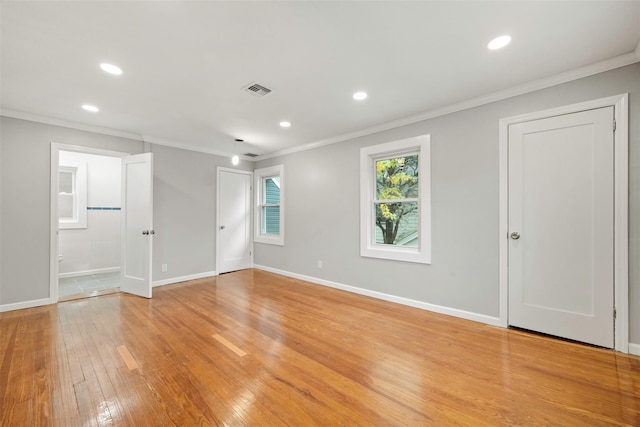 spare room featuring ornamental molding and light wood-type flooring