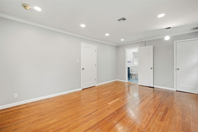 spare room featuring ornamental molding and light hardwood / wood-style floors