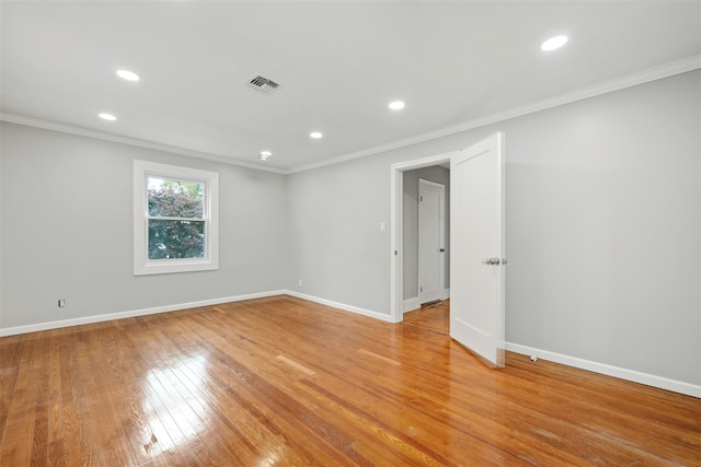 spare room with ornamental molding and light hardwood / wood-style floors