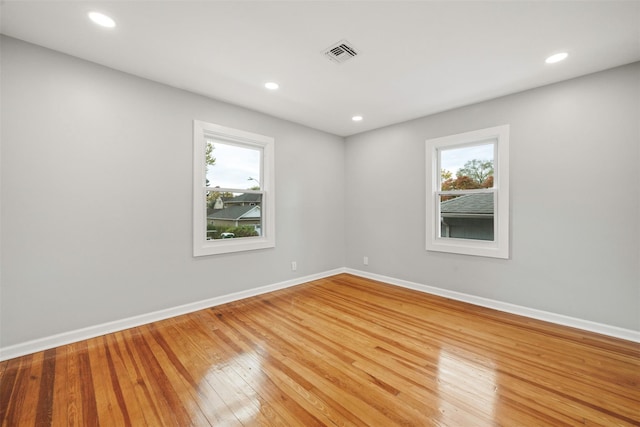 spare room with hardwood / wood-style floors and a healthy amount of sunlight