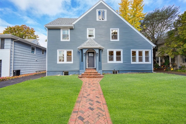 view of front of property with roof with shingles and a front lawn