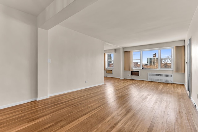 unfurnished living room featuring hardwood / wood-style floors and radiator heating unit