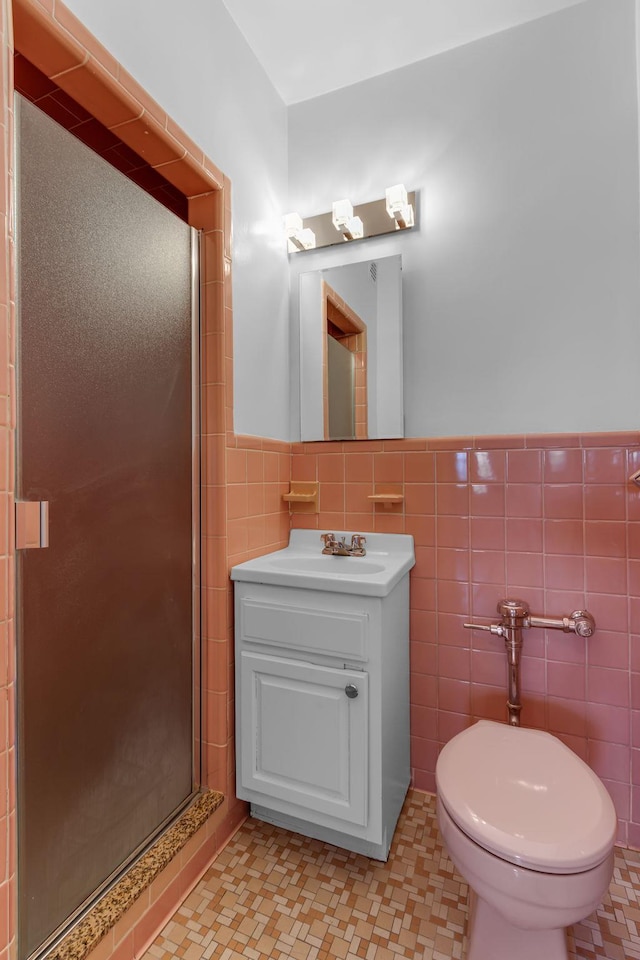 bathroom with tile walls, vanity, toilet, and walk in shower