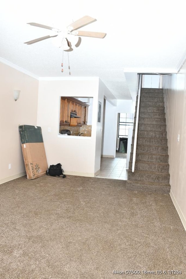 unfurnished living room featuring light carpet, ornamental molding, and ceiling fan