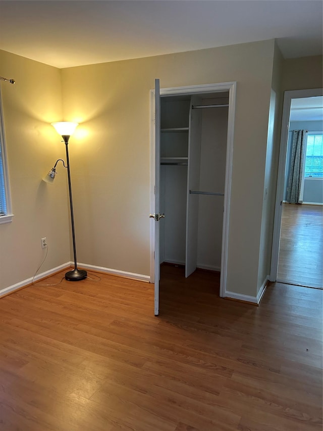 unfurnished bedroom with wood-type flooring and a closet