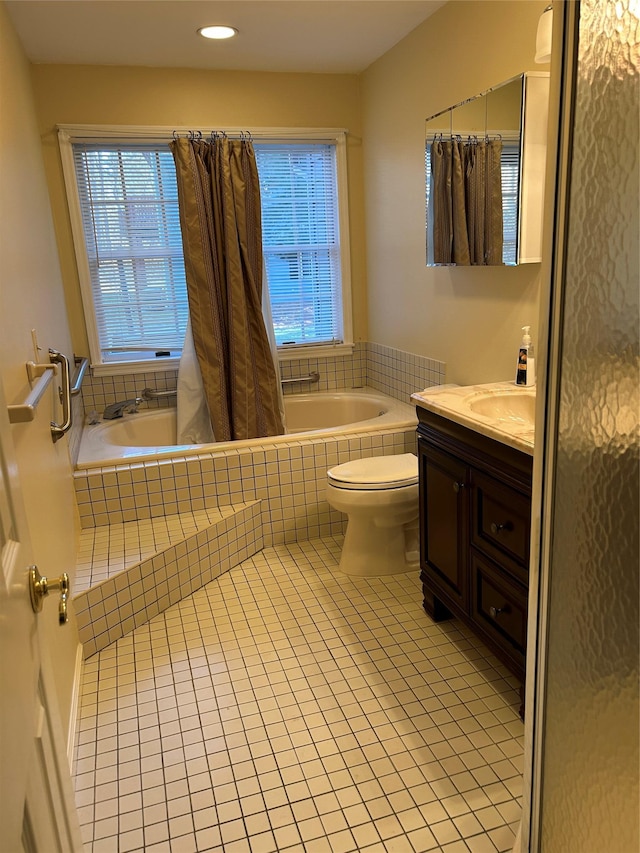 bathroom with vanity, toilet, tile patterned flooring, and tiled bath