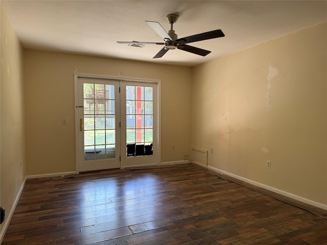 spare room featuring dark wood finished floors, ceiling fan, and baseboards
