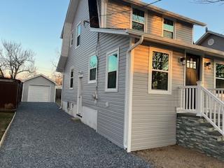 view of front of property with a garage and an outbuilding