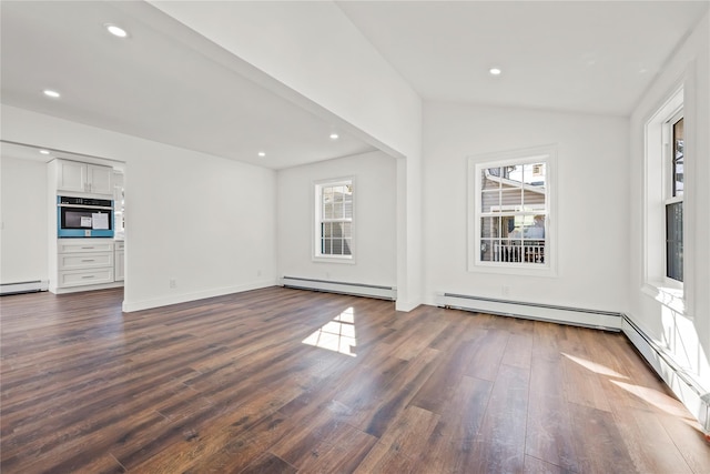 empty room featuring dark wood-type flooring, a baseboard radiator, and recessed lighting