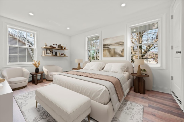 bedroom with recessed lighting, a baseboard radiator, baseboards, and wood finished floors