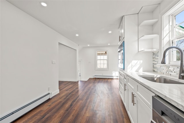 kitchen with light stone counters, open shelves, stainless steel appliances, a baseboard heating unit, and white cabinetry