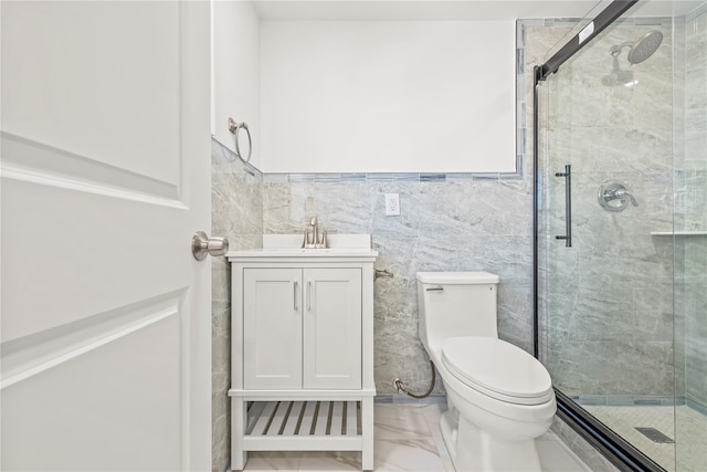 bathroom featuring marble finish floor, tile walls, toilet, a stall shower, and vanity