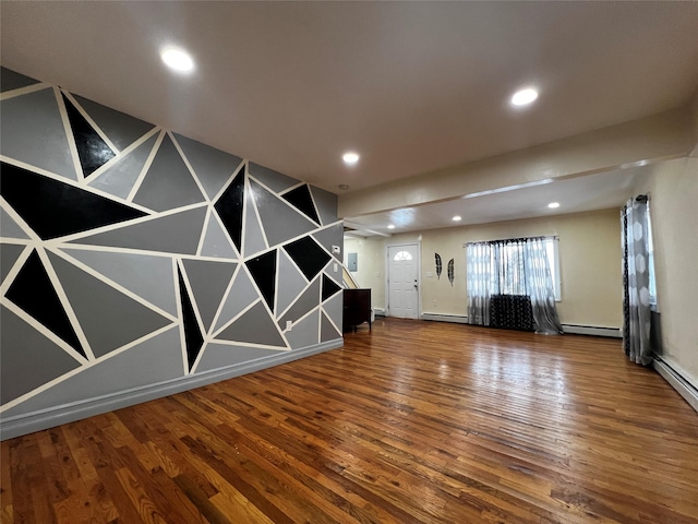 spare room featuring hardwood / wood-style flooring and a baseboard heating unit