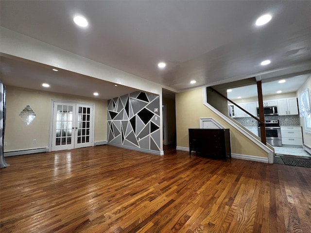 basement with dark hardwood / wood-style floors, baseboard heating, and french doors