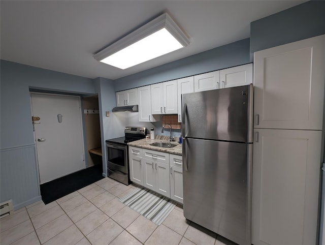 kitchen featuring light tile patterned flooring, appliances with stainless steel finishes, white cabinetry, sink, and light stone counters