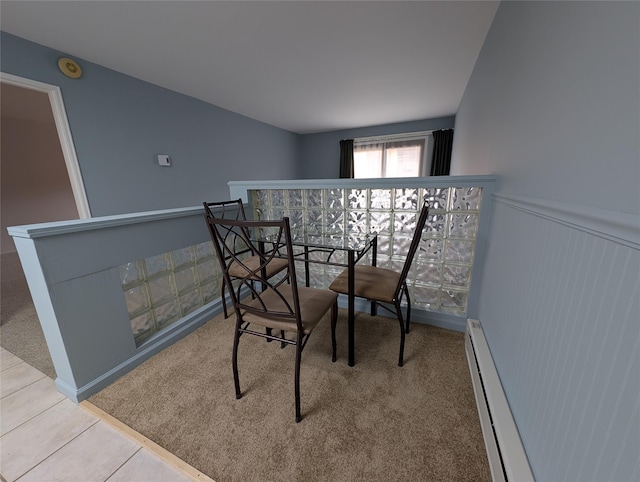 tiled dining area with a baseboard heating unit