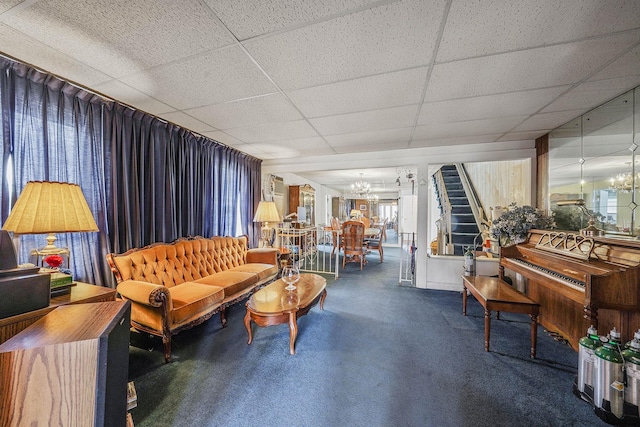 living room with a paneled ceiling and a chandelier