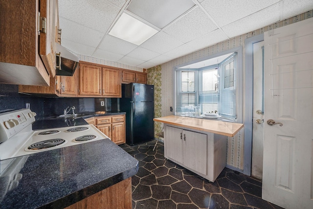 kitchen featuring white electric range, a paneled ceiling, butcher block countertops, sink, and black fridge