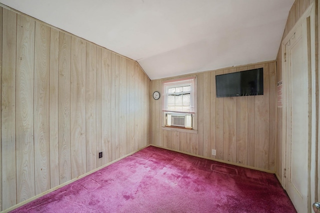 carpeted spare room featuring cooling unit, lofted ceiling, and wood walls