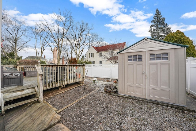 view of yard featuring a wooden deck and a storage shed