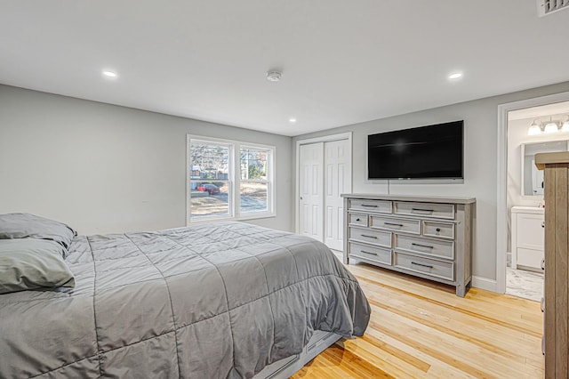 bedroom featuring connected bathroom, a closet, and light wood-type flooring