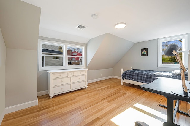 bedroom featuring lofted ceiling and light hardwood / wood-style floors