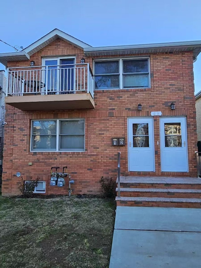 view of front of property featuring a balcony and a front yard