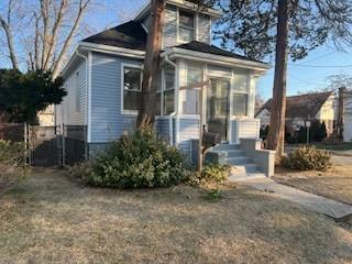 view of front facade with a sunroom and a front lawn