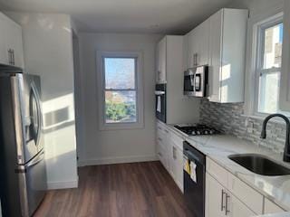 kitchen featuring white cabinetry, light stone countertops, sink, and black appliances