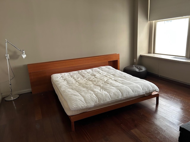 bedroom with dark wood-type flooring