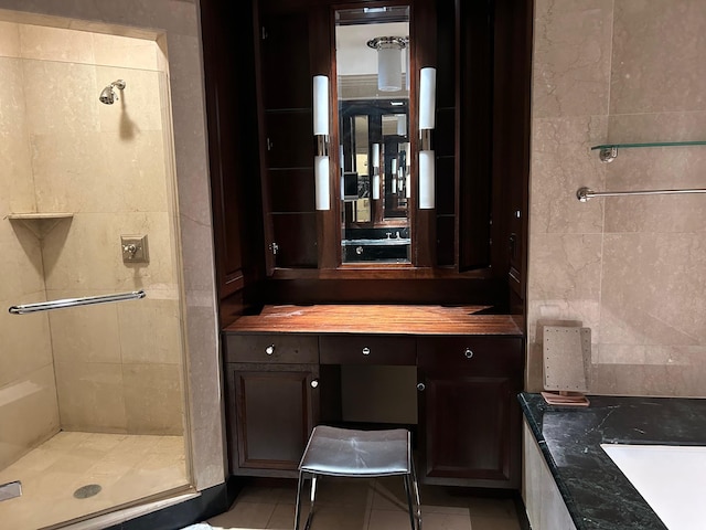 bathroom featuring walk in shower, vanity, and tile patterned flooring