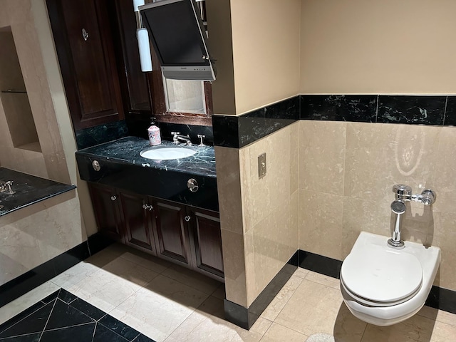 bathroom with tile walls, vanity, tile patterned floors, and toilet