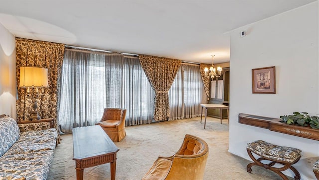 carpeted living room featuring a notable chandelier