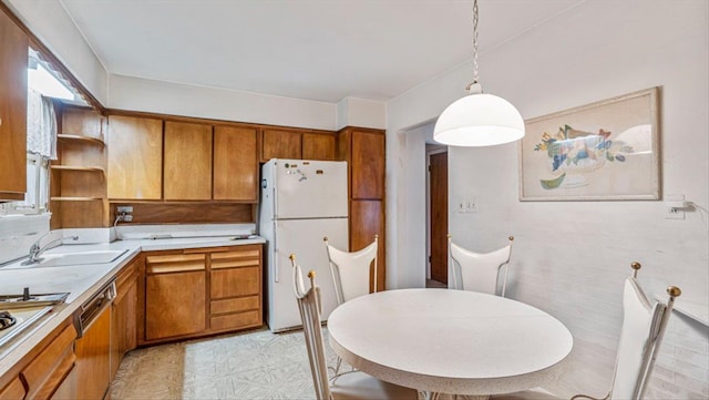 kitchen with hanging light fixtures, dishwasher, white fridge, and sink