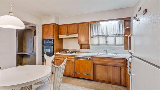 kitchen featuring dishwashing machine, sink, hanging light fixtures, white refrigerator, and oven