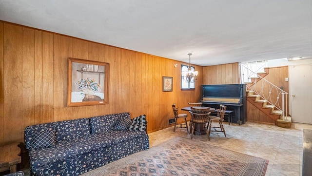 living room featuring a chandelier and wood walls