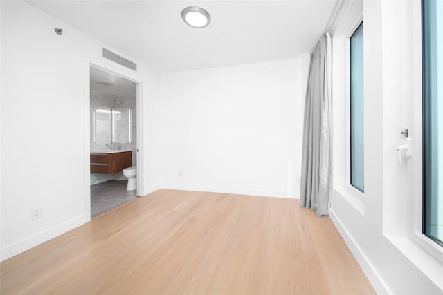 spare room featuring a wealth of natural light and light hardwood / wood-style flooring