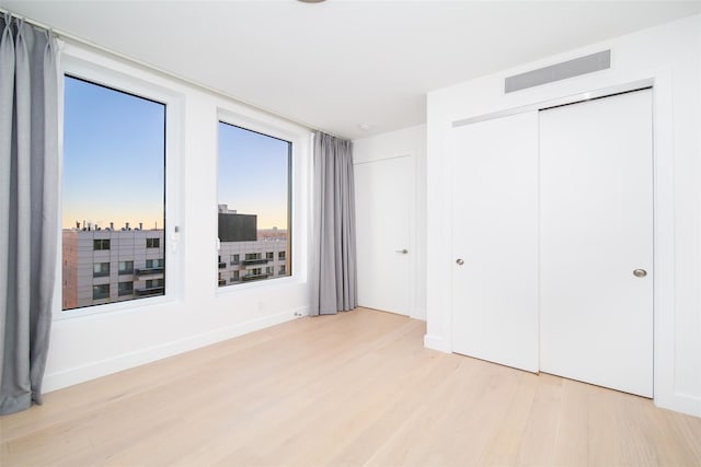 unfurnished bedroom with a closet and light hardwood / wood-style flooring