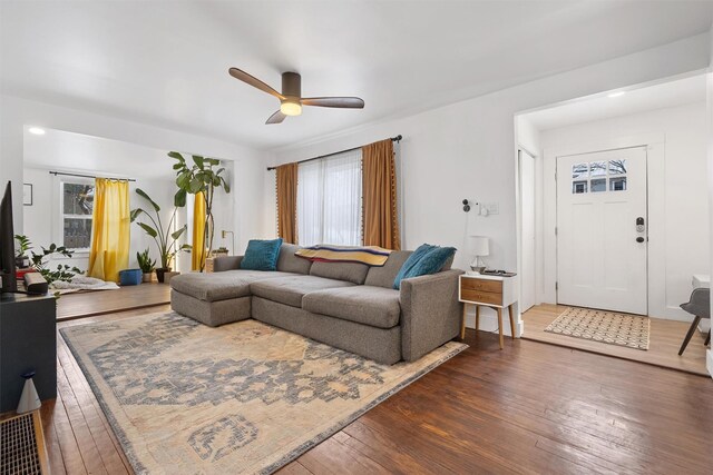 living room with ceiling fan and dark hardwood / wood-style flooring