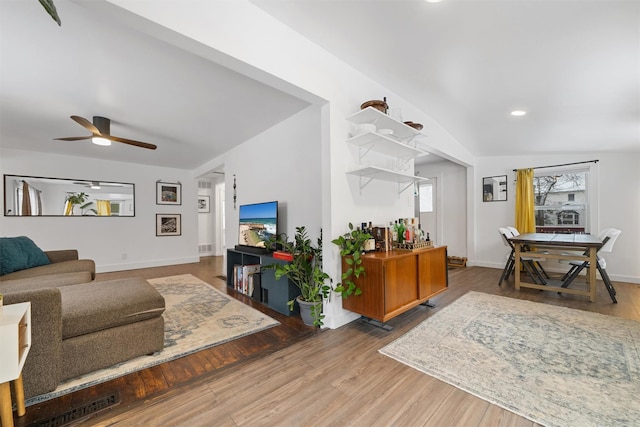 living room featuring ceiling fan, wood-type flooring, and a healthy amount of sunlight