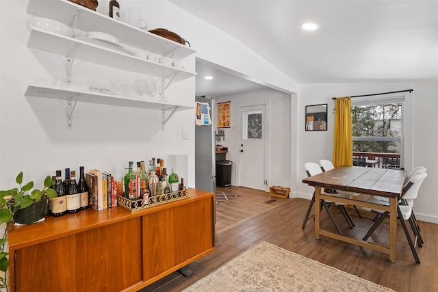 bar with dark hardwood / wood-style flooring and vaulted ceiling