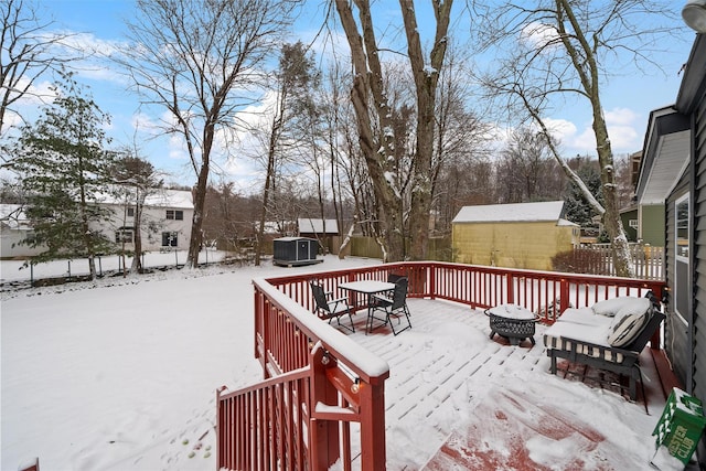 snow covered deck featuring a storage unit