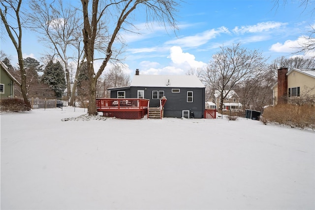 snow covered house featuring a wooden deck