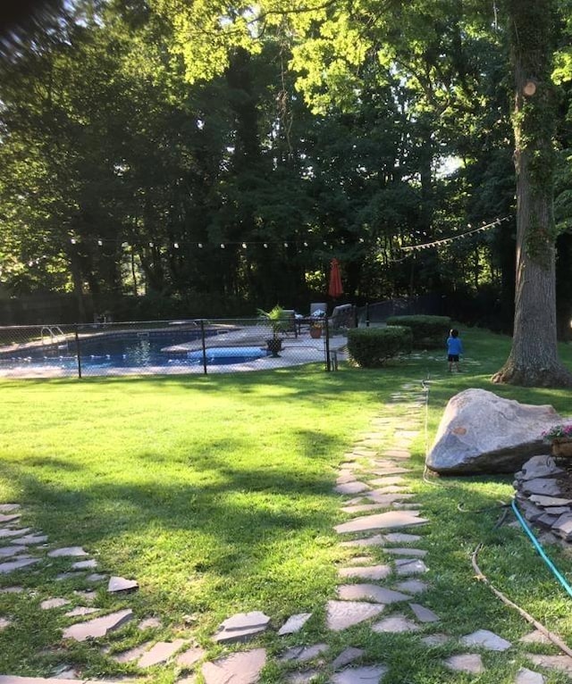 view of community with a yard and a swimming pool