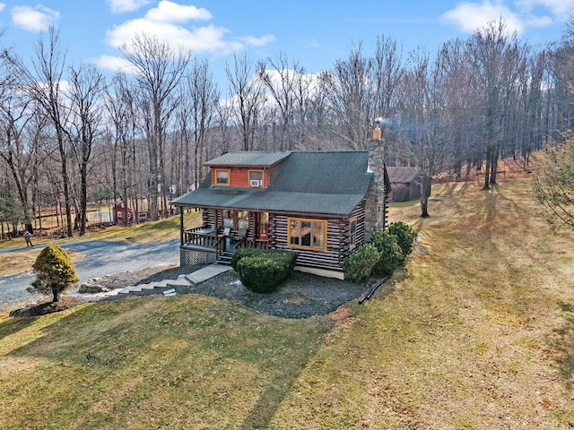 log cabin with a front yard and covered porch