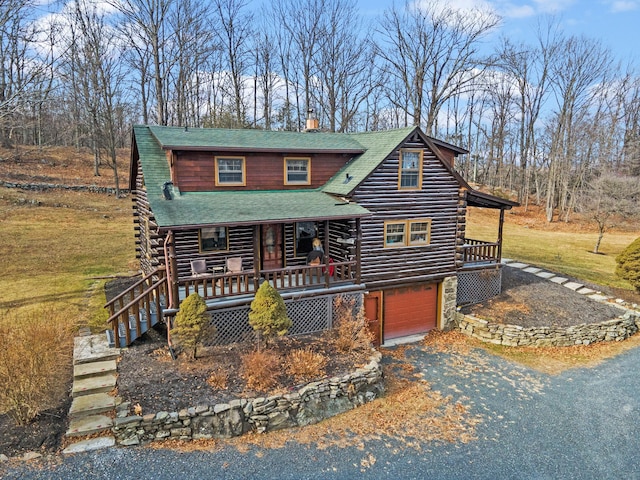 log-style house featuring a garage and a porch